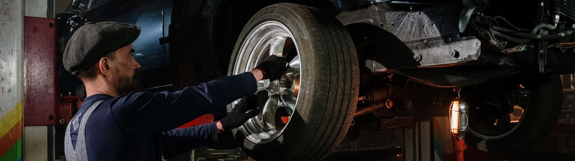 Mechaniker wechselt das Rad an einem Fahrzeug